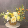 Yellow and white floral arrangement in a pumpkin-shaped vase