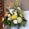 Yellow and white floral arrangement in a light blue vase