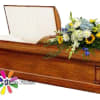 Wooden casket with a mixed floral spray on top