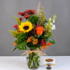 Mixed bouquet in a glass vase with a sunflower and orange rose