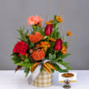 Fall bouquet with red roses, carnations, and orange mums in a plaid container