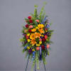 Tall standing floral spray with mixed bright flowers on a tripod easel