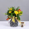 Yellow flowers in a patterned black pot with a decorative ribbon