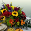 Colorful autumn floral arrangement with sunflowers and red blooms in a basket