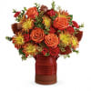 Orange roses and red-yellow mums in a red vase
