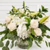 White roses and lilies arranged in a glass vase
