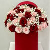 Red and blush roses arranged in a red hat box