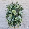 Large white and green floral standing spray on an easel