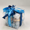 Clear gift box filled with assorted chocolates and tied with a blue ribbon