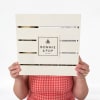 Person holding a wooden crate with a Bonnie & Pop label