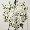 White floral heart wreath with a satin ribbon on a black easel