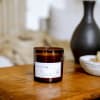 Brown glass candle jar on a wooden table