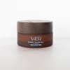 Brown cosmetic balm jar with a wooden lid on a white background