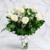 White roses in a clear glass vase with a white ribbon