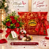Red roses in a glass vase beside a red chocolate gift box