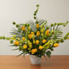 Yellow roses and snapdragons arranged in a white pot