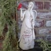 Angel figurine holding a red bird beside trailing greenery