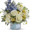 Blue and white floral arrangement in a clear square vase