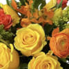 Bouquet of yellow, orange, and red roses with small orange flowers
