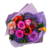 Colorful bouquet with gerbera daisies, roses, and calla lilies in purple wrap