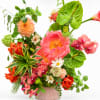 Colorful floral arrangement in a pink container with large pink blooms