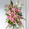 Pink and white floral standing spray on a black easel