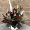 White Ceramic Pumpkin with a mix of fall colored flowers, pampas grass