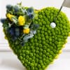 Heart-shaped floral arrangement with yellow roses and blue thistles
