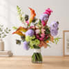 Colorful bouquet with calla lilies, hydrangeas, and snapdragons in a glass vase