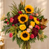Bouquet of sunflowers, roses, and chrysanthemums in a glass vase