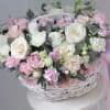 Pink and white roses with carnations in a white basket