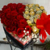 Heart-shaped bouquet of red roses and gold-wrapped chocolates with a red bow