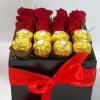 Red roses and gold-wrapped chocolates in a black gift box with a red ribbon