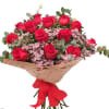 Bouquet of red roses with pink filler flowers and a red ribbon