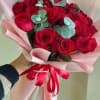 Bouquet of red roses with eucalyptus wrapped in pink paper