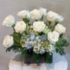 Elegant arrangement featuring premium white roses, blue hydrangeas and fresh greenery. Perfect