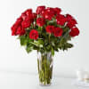 Tall arrangement of long-stem red roses in a clear glass vase