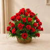 Basket arrangement of red roses with greenery