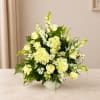 White and pale yellow floral arrangement in a white vase