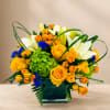 Yellow roses and white lilies in a square glass vase