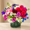 Mixed bouquet of roses and daisies in a green glass vase