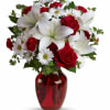 Bouquet of red roses, white lilies, and white daisies in a red vase
