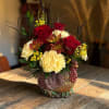 Red roses and cream flowers arranged in a decorative turkey vase