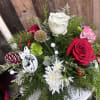 Holiday table centerpiece mixed with colorful flowers to bring in festive cheer.