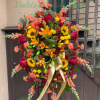 A bold cascade of sunflowers, lilies, roses and warm-toned blooms makes this