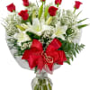 Bouquet of red roses and white lilies in a glass vase with a red bow