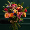 Hand-tied bouquet of orange, pink, and purple flowers