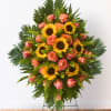 Standing floral spray with sunflowers and pink roses on a metal easel
