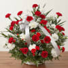 Red and white carnation arrangement in a white basket with a silver ribbon