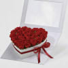 Heart-shaped box filled with red roses and tied with a red ribbon